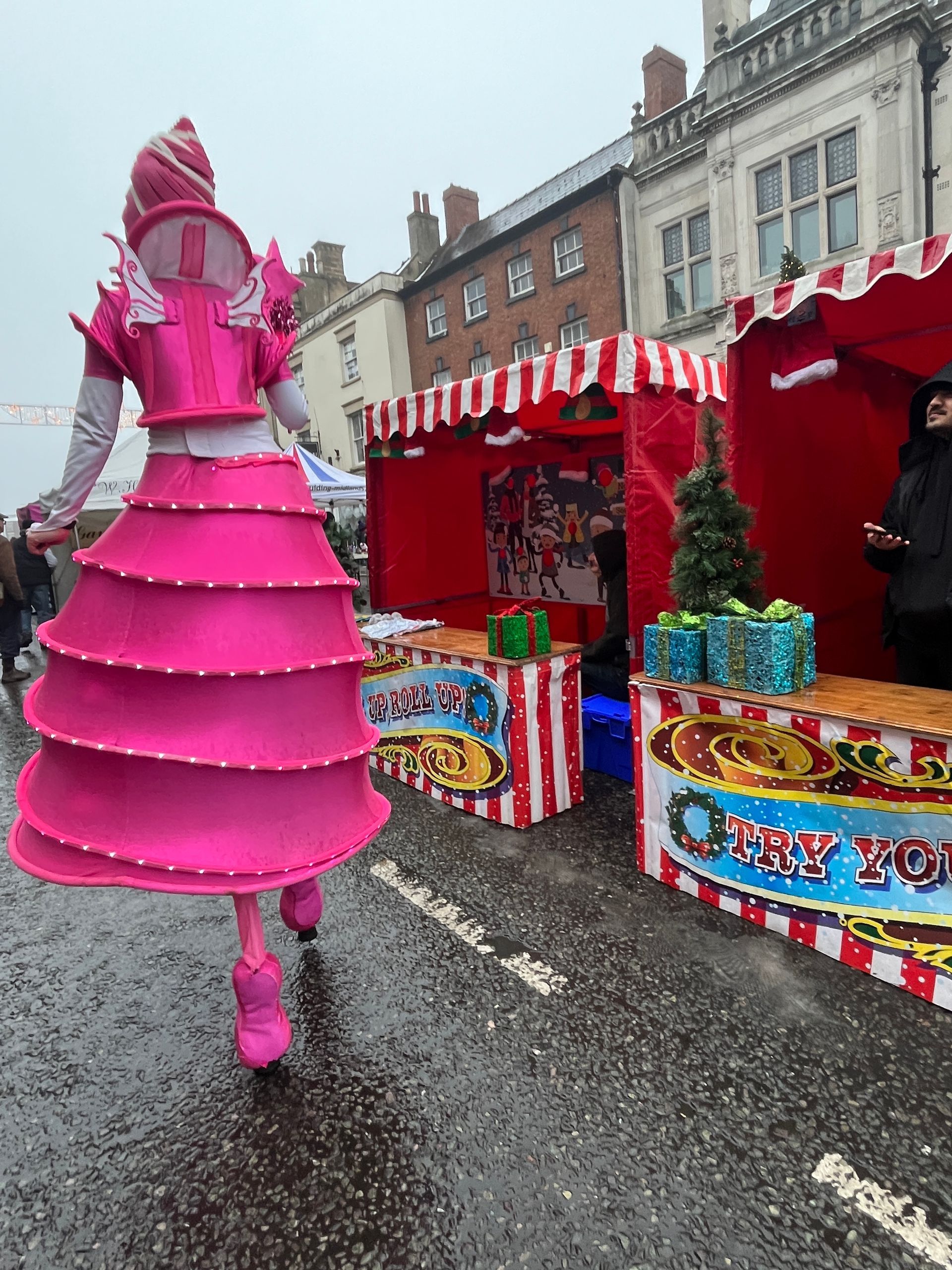 A woman in a pink dress is walking down a street.