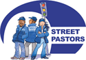 A group of street pastors are standing next to each other in front of a traffic light.