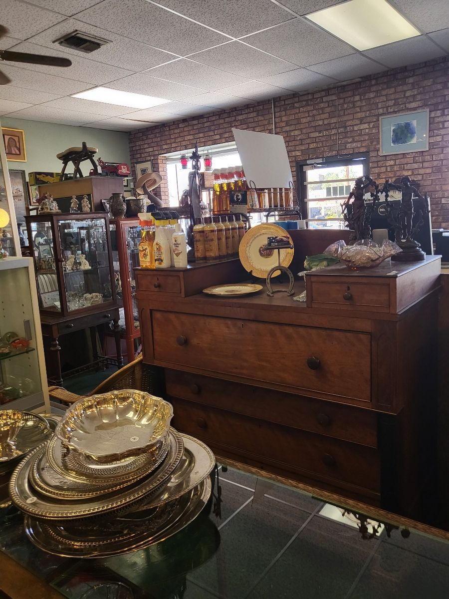Antique store interior, featuring a display counter with various items and shelves filled with merchandise.