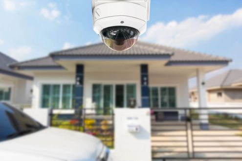 Telecamera di sicurezza che inquadra una casa moderna con vialetto e auto parcheggiata