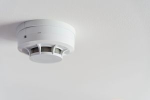 Rivelatore di fumo bianco montato su un soffitto bianco