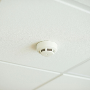 Rivelatore di fumo bianco montato su un soffitto con finitura a rilievo