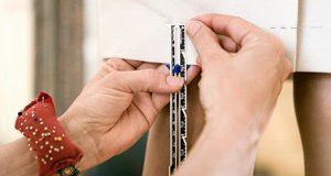 A person is measuring a piece of paper with a ruler.