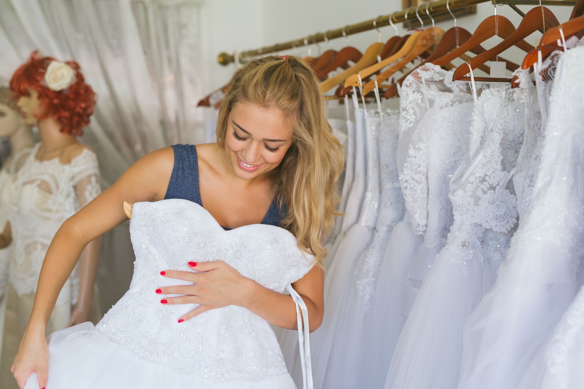 A woman is trying on a wedding dress in a bridal shop.