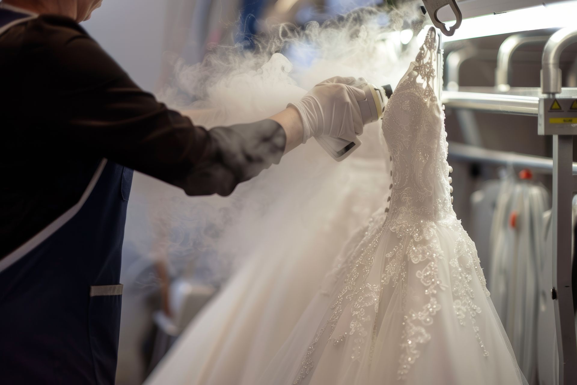 A man is steaming a wedding dress in a factory.