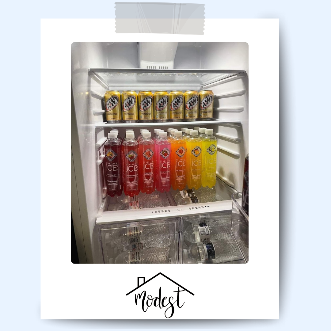 Refrigerator filled with colorful beverages and cans, neatly arranged.
