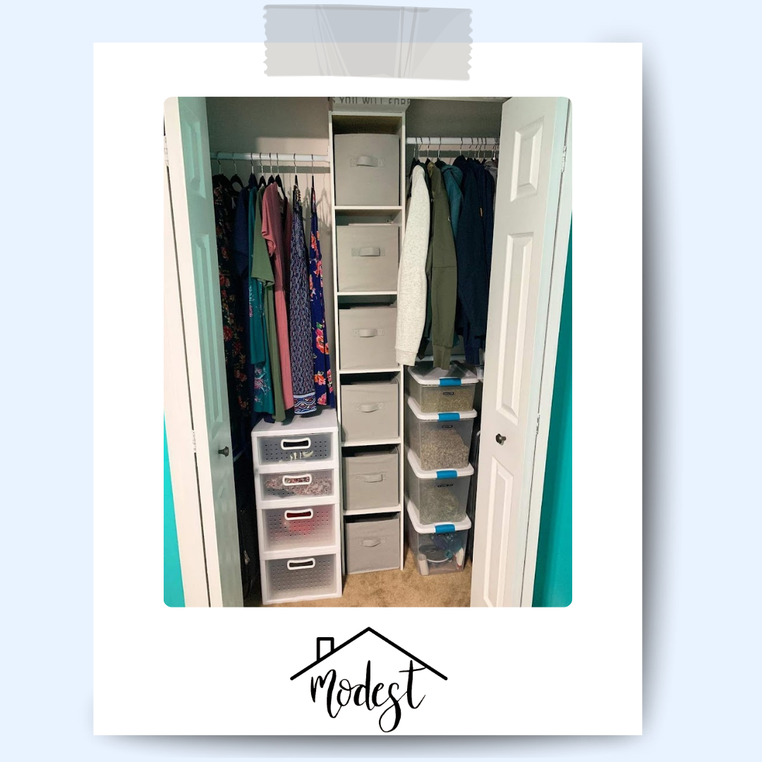 Closet with clothes on hangers and storage bins.