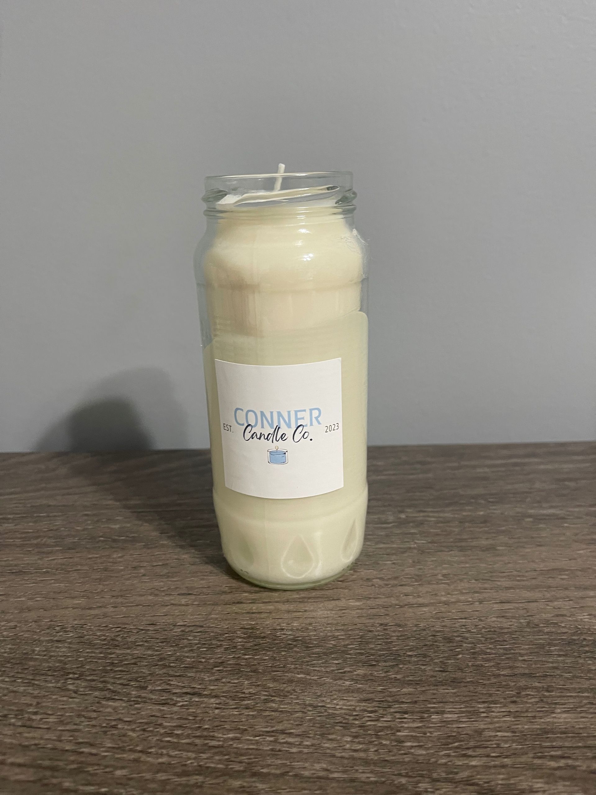 White candle in a glass jar, with a label reading "Connor's Farm Pie."