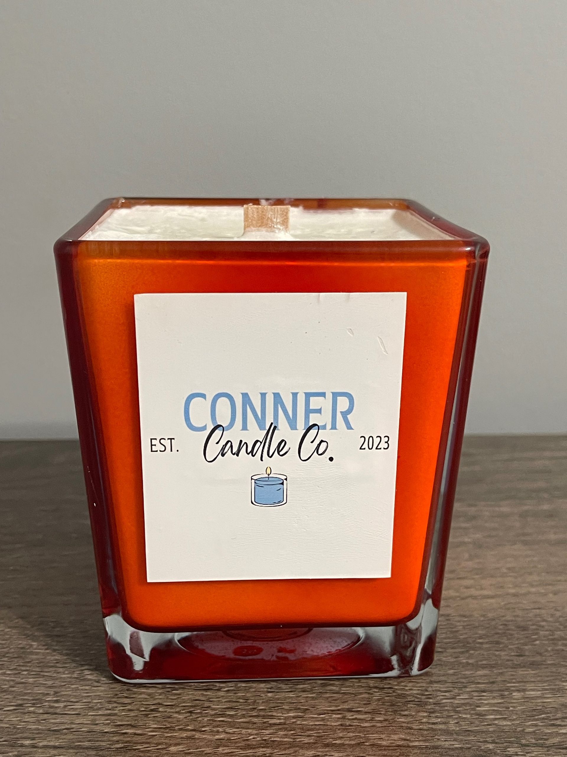 Orange square candle with white label: "CONNER Candle Co."