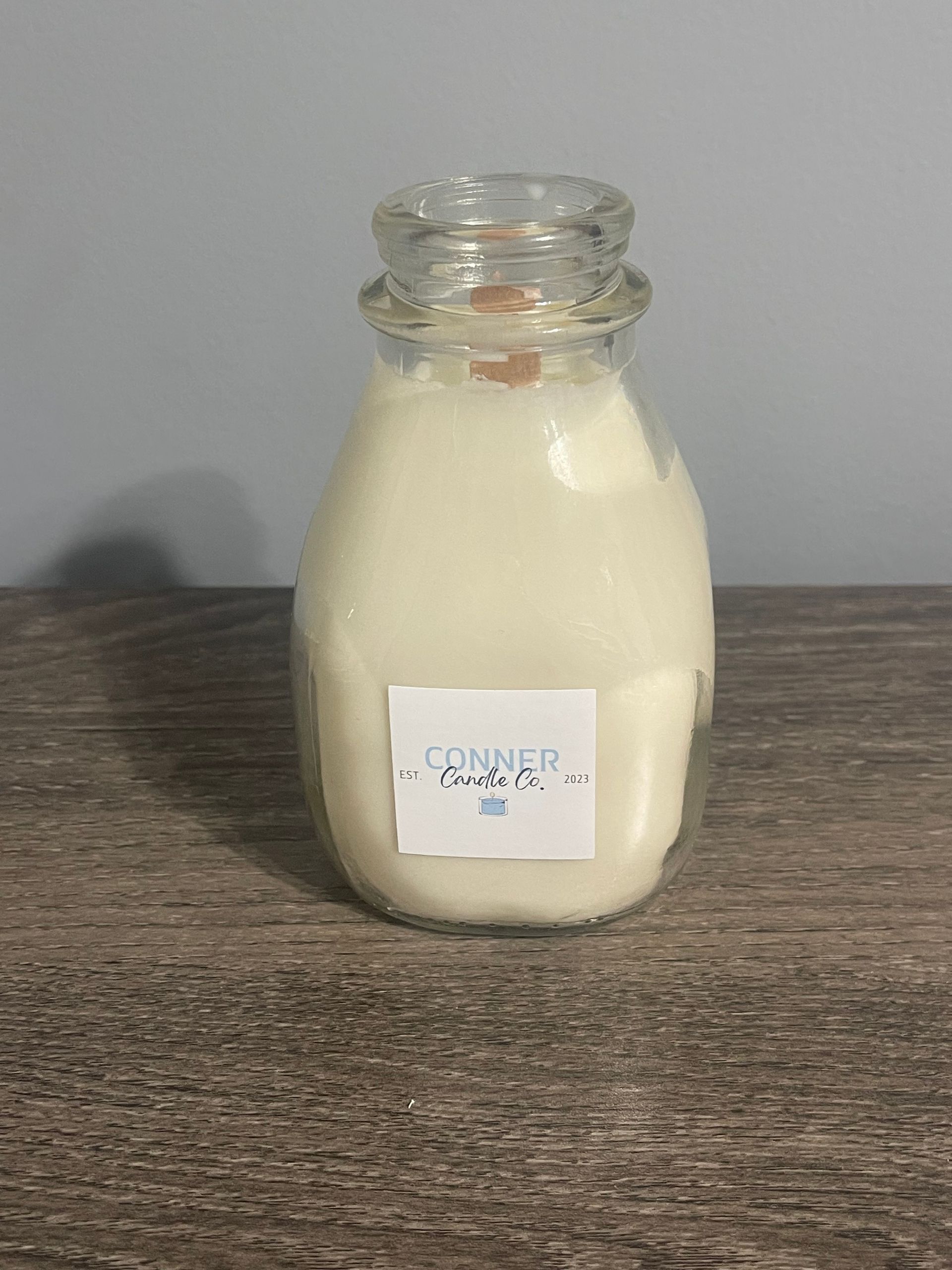 Glass milk bottle filled with white powder, label reads "CONNER POWDER".