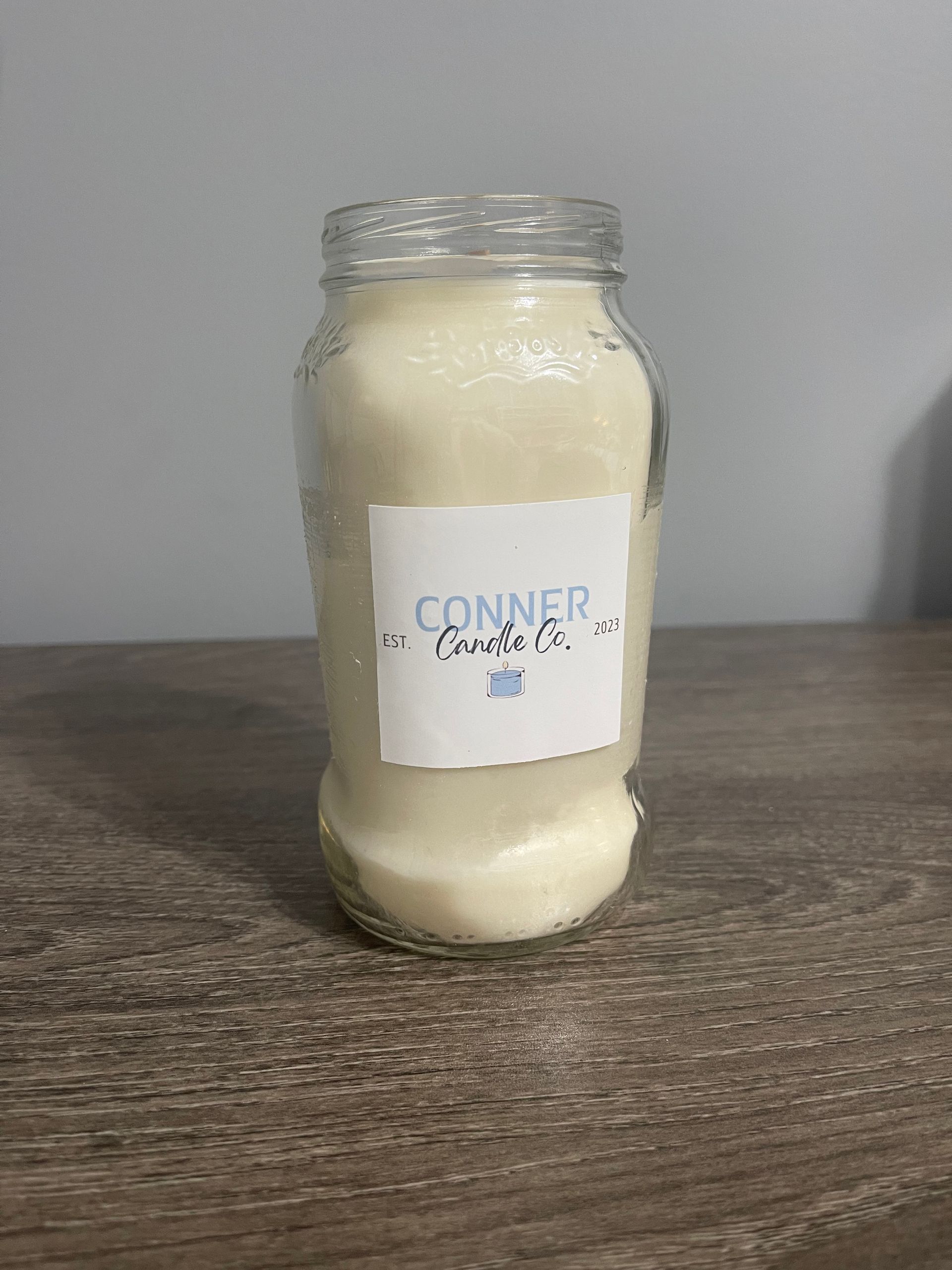 A jar filled with white powder on a wooden surface with a label that says "Connor & Co."