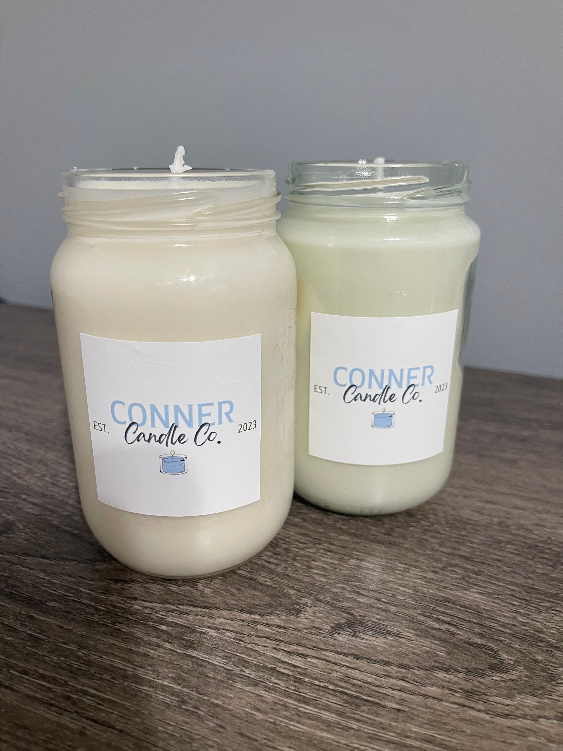 Two jar candles with white labels that say 