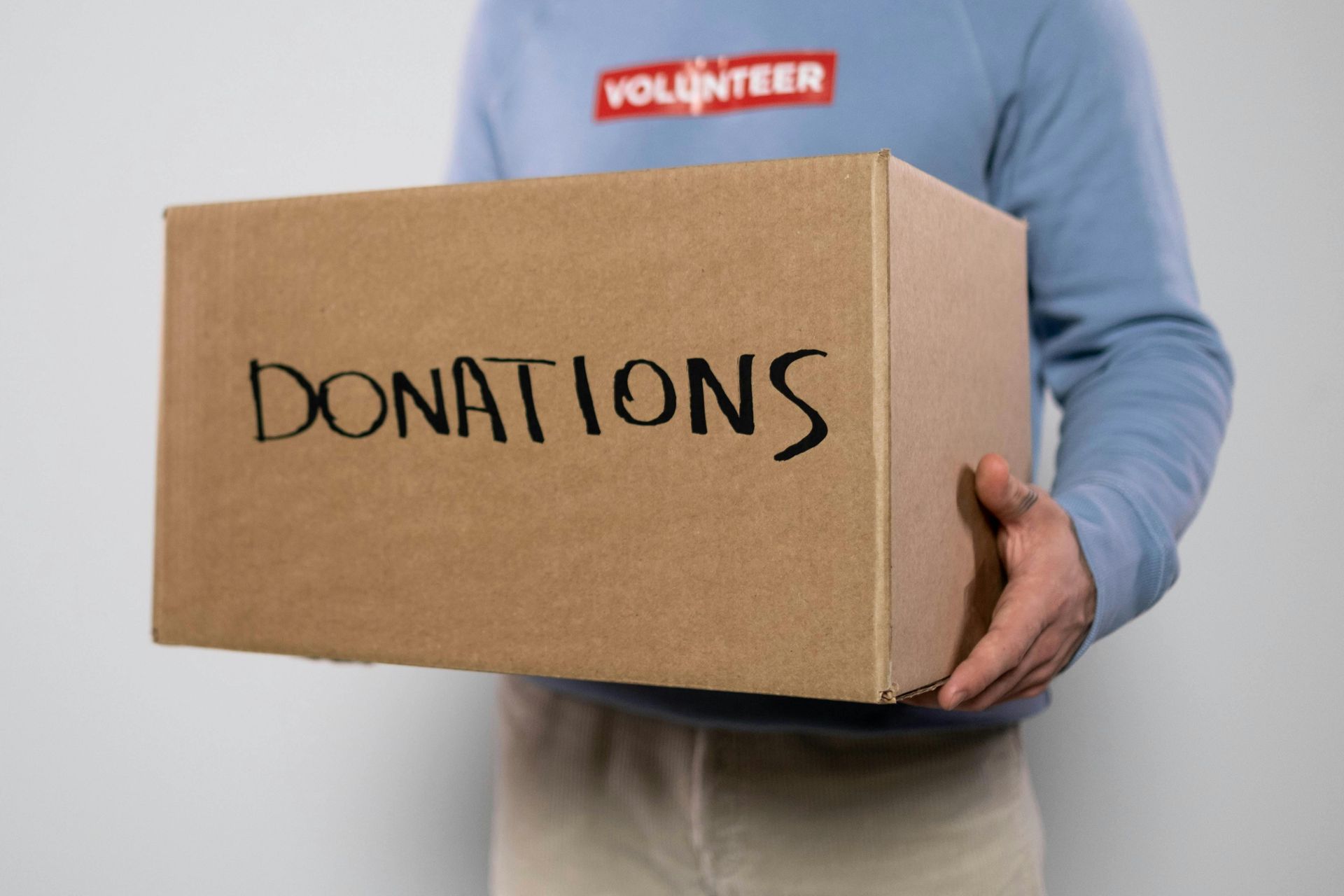 Person holding a cardboard box labeled