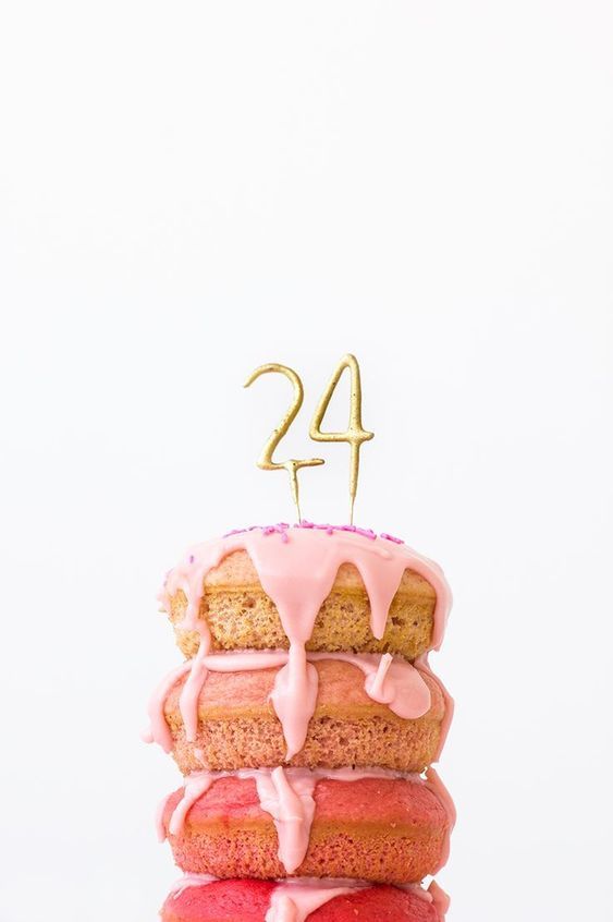 Stack of three donuts with pink icing and a golden