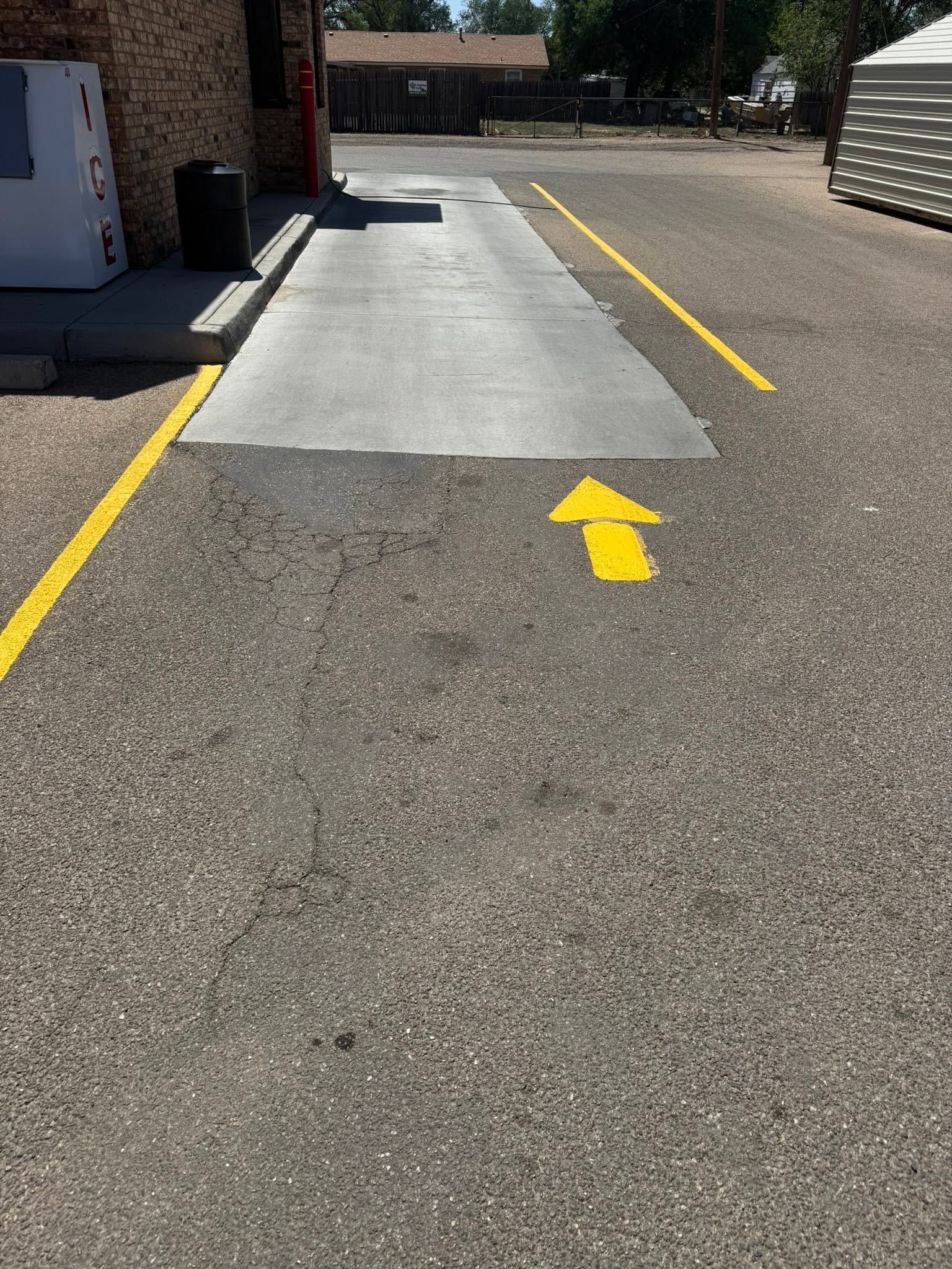 Yellow arrows mark a wheelchair ramp leading to a building entrance beside a parking lot.