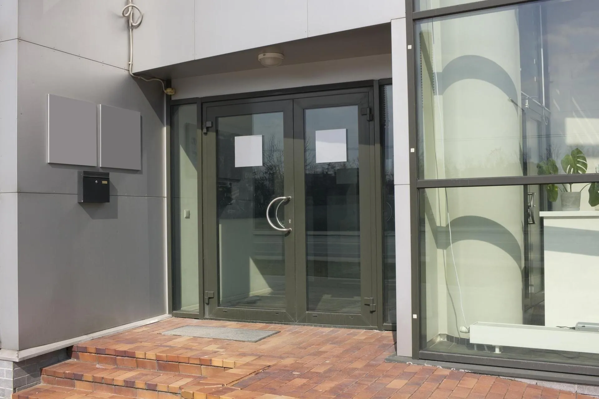 A building with a large glass door and stairs leading to it.