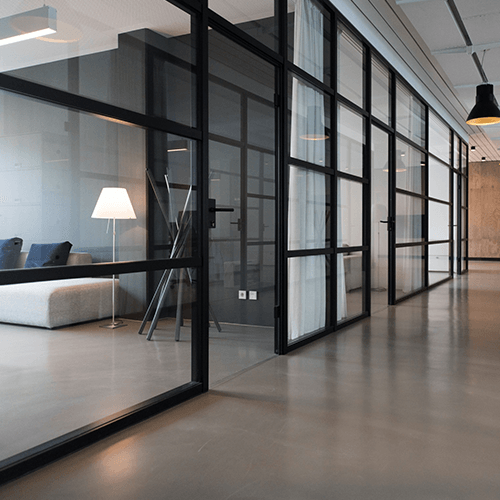 A long hallway with a lot of windows and a lamp.