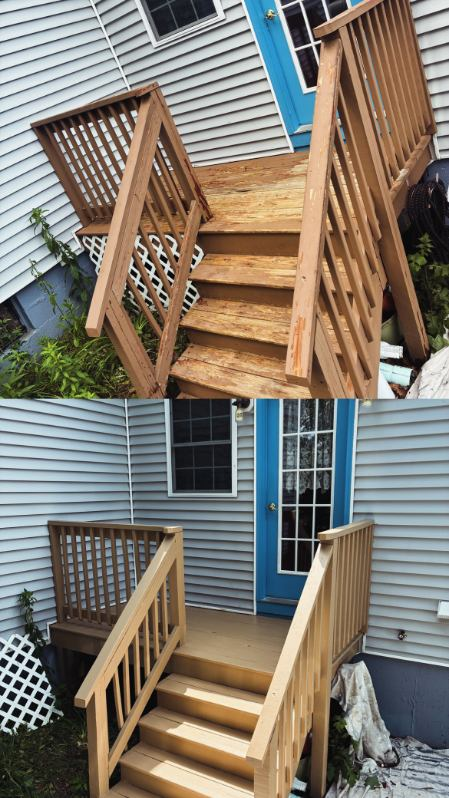 Four workers paint the exterior of a light-gray house white using paint rollers on a wooden deck.