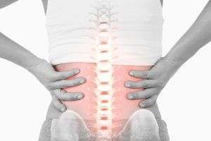 A person is holding their back in pain.