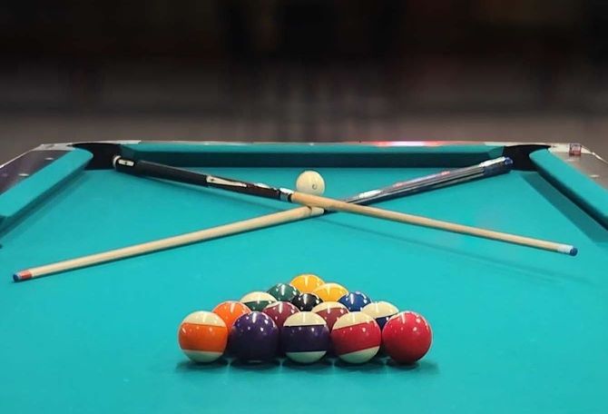 Pool Leagues A pool table with balls and cues on it