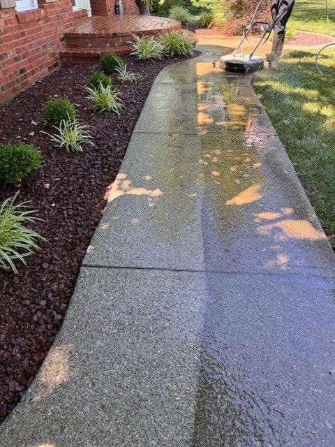 A person is cleaning a sidewalk in front of a house. - Bourbon City Softwash - Louisville, KY