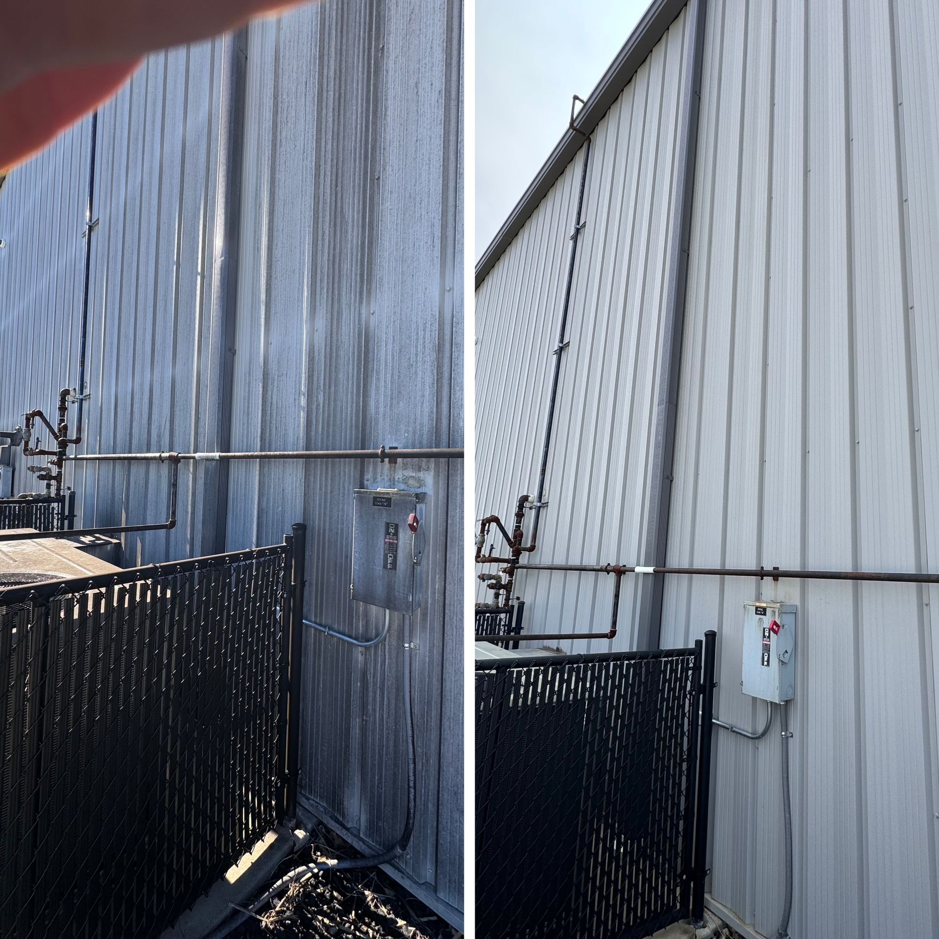 Side-by-side: building exterior before and after cleaning. Grimy gray siding is now clean white. Black fence in foreground.