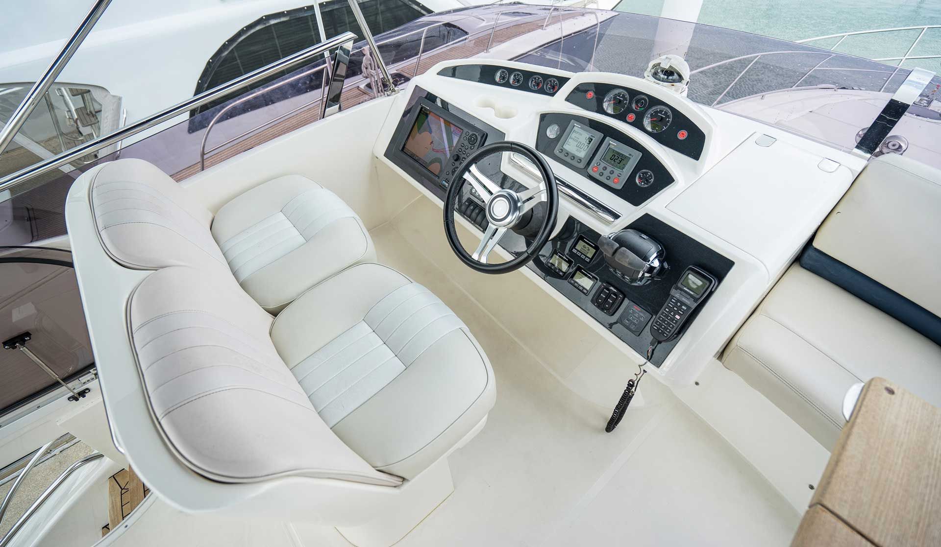 The cockpit of a boat with a steering wheel and a seat