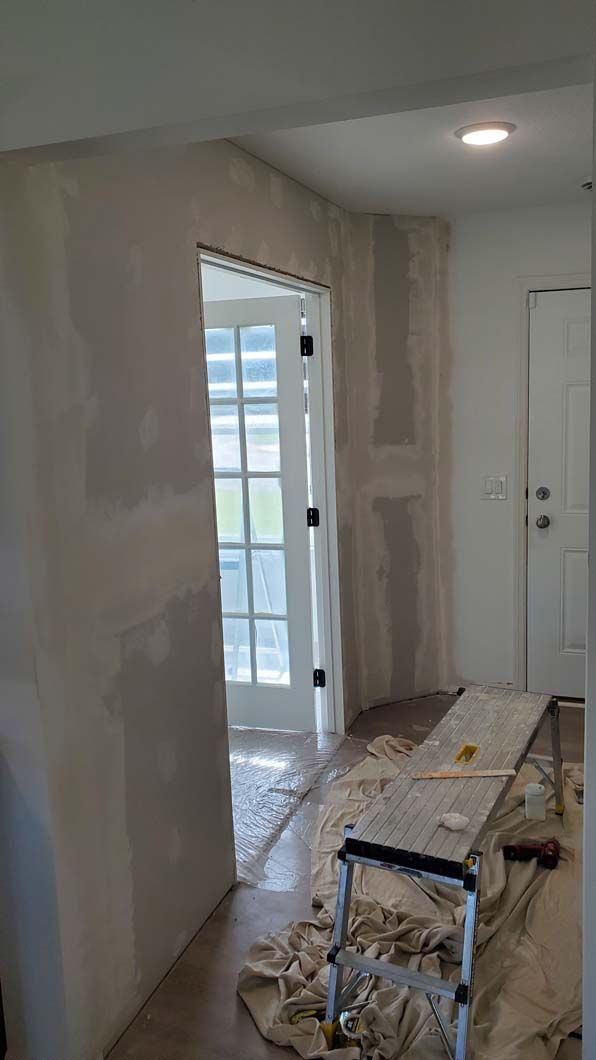 A room with a ladder and a table in it is being painted.