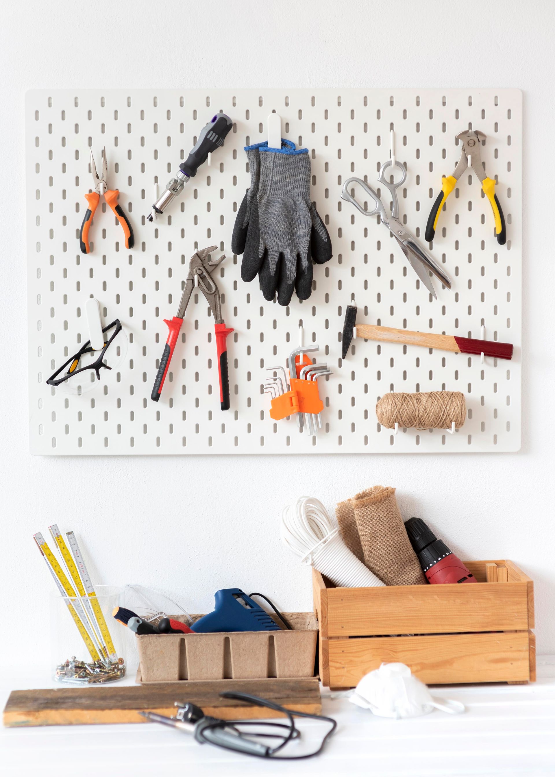 A bunch of tools are hanging on a wall.