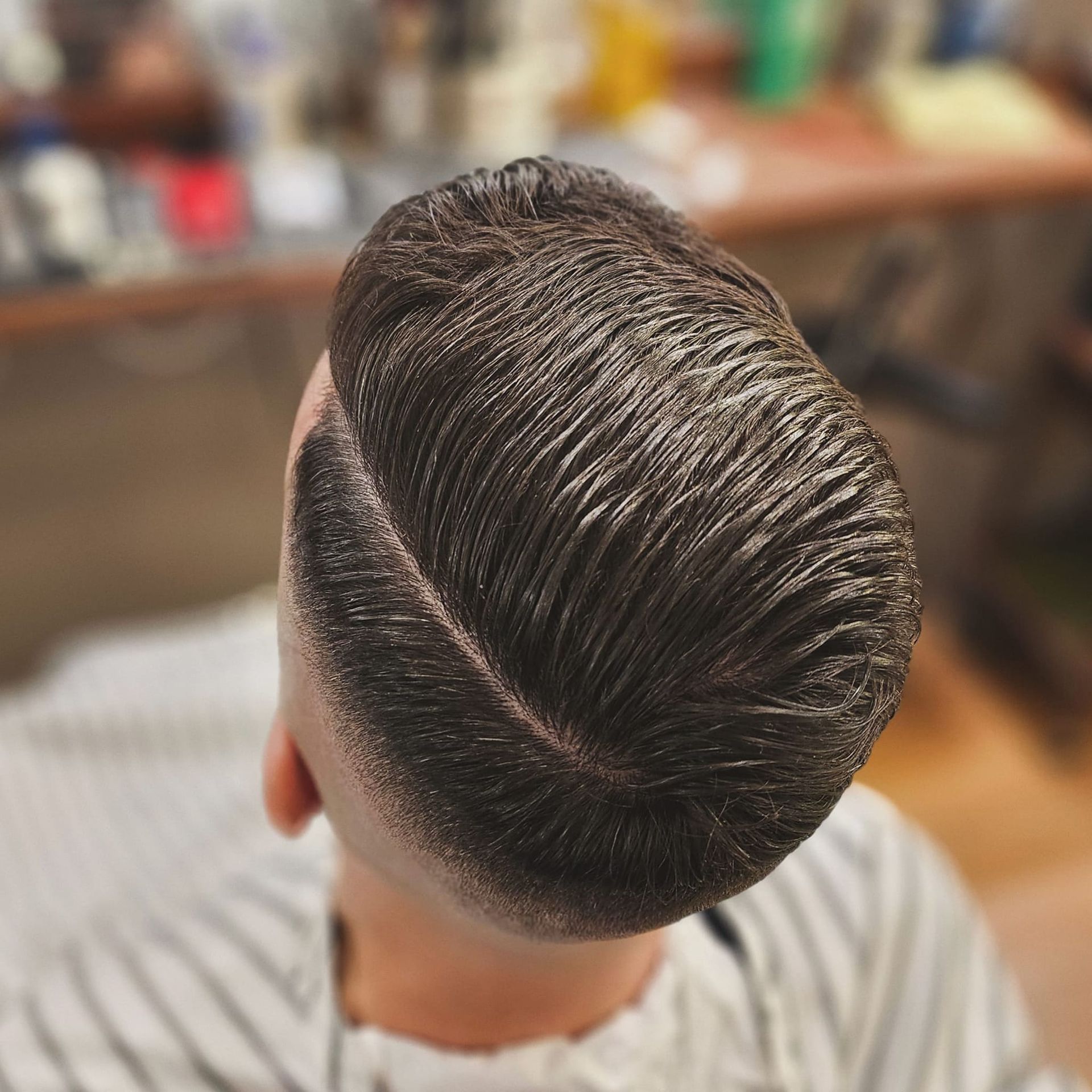 Sleek, Side-parted Men’s Haircut With Dark Hair in a Barbershop Chair — Lucky Child Barber Shop In Hobart, TAS