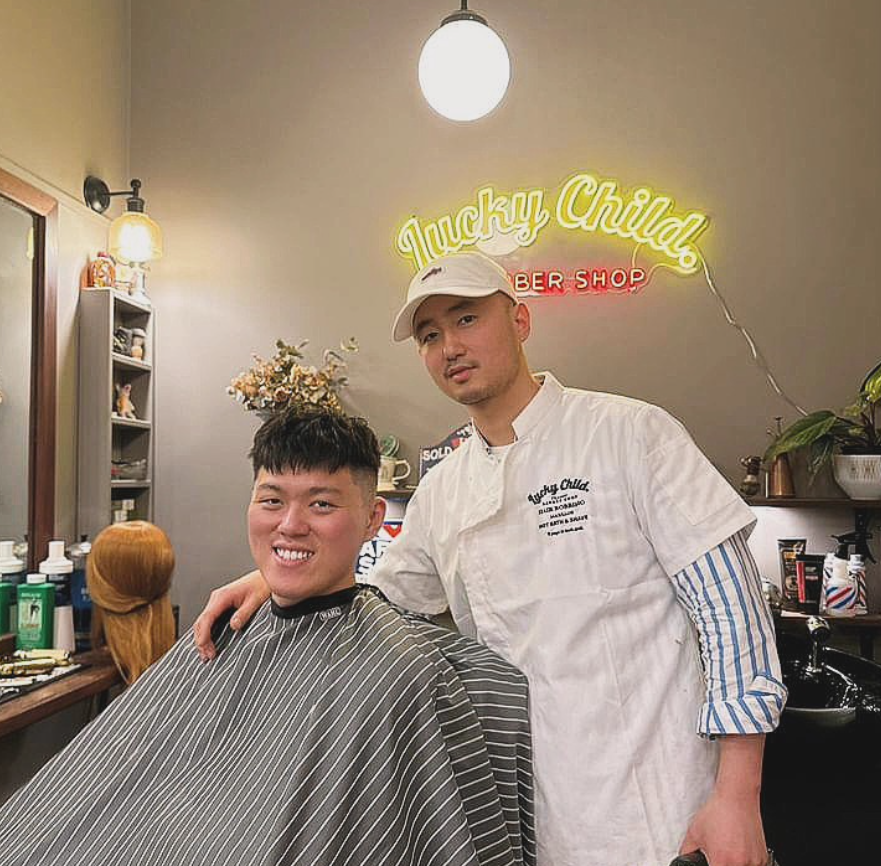 Barber Shop Interior With Barber Standing Beside a Smiling Customer — Lucky Child Barber Shop In Hobart, TAS