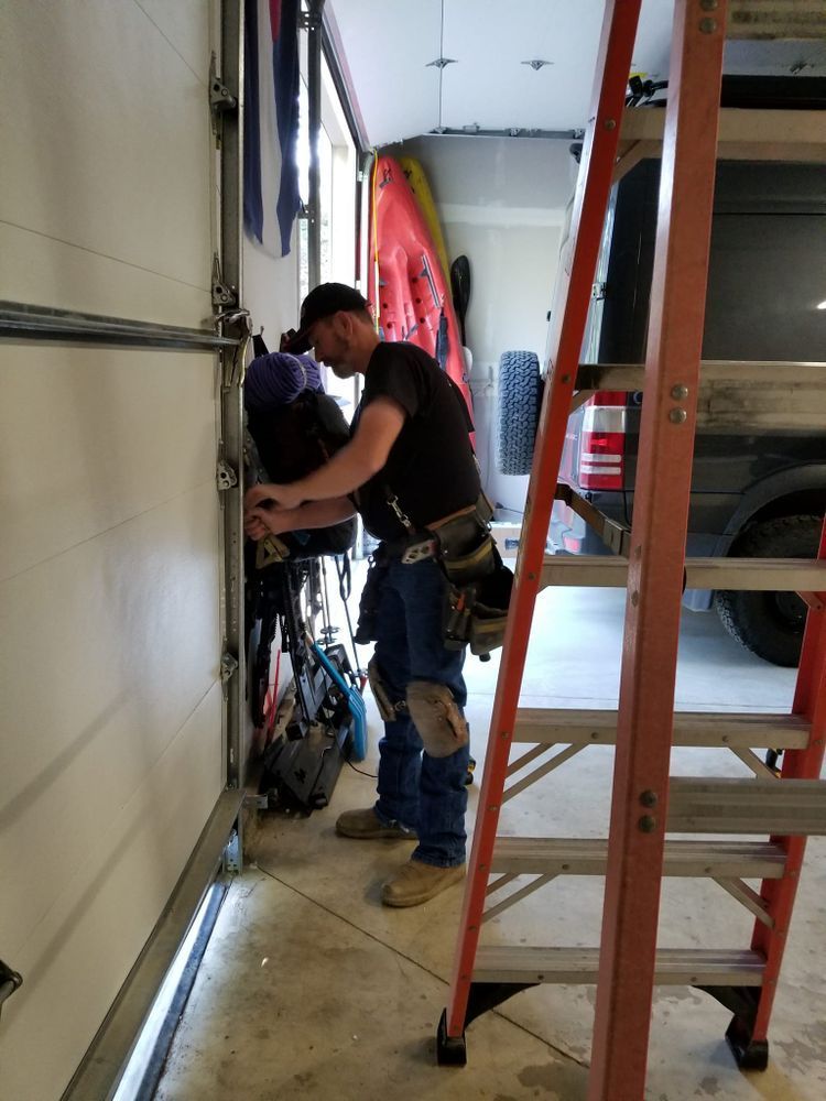 Two workers in orange safety gear standing in a white industrial loading bay doorway