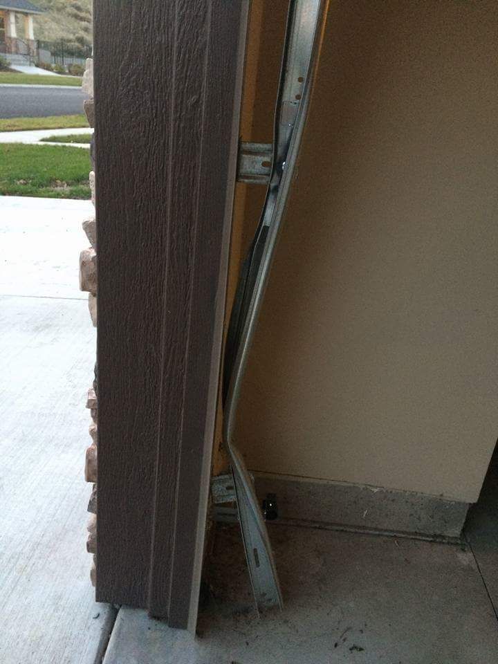 Broken garage door track with metal bracket leaning against the doorway.