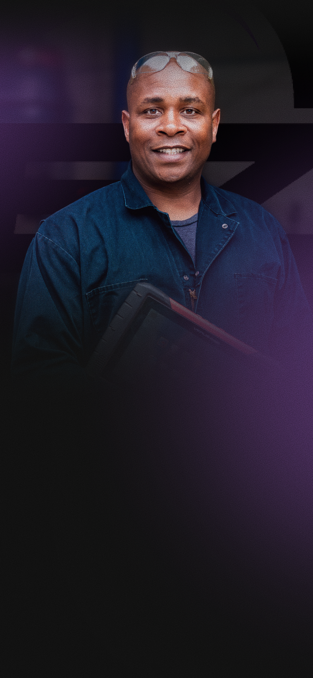 Smiling man in a dark jacket against a purple-black gradient background | EZT Auto and Transmissions