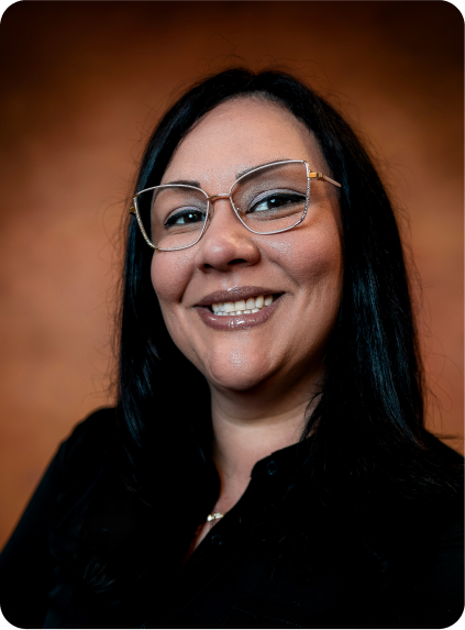 Smiling woman with glasses and long dark hair against a warm brown background | EZT Auto and Transmissions