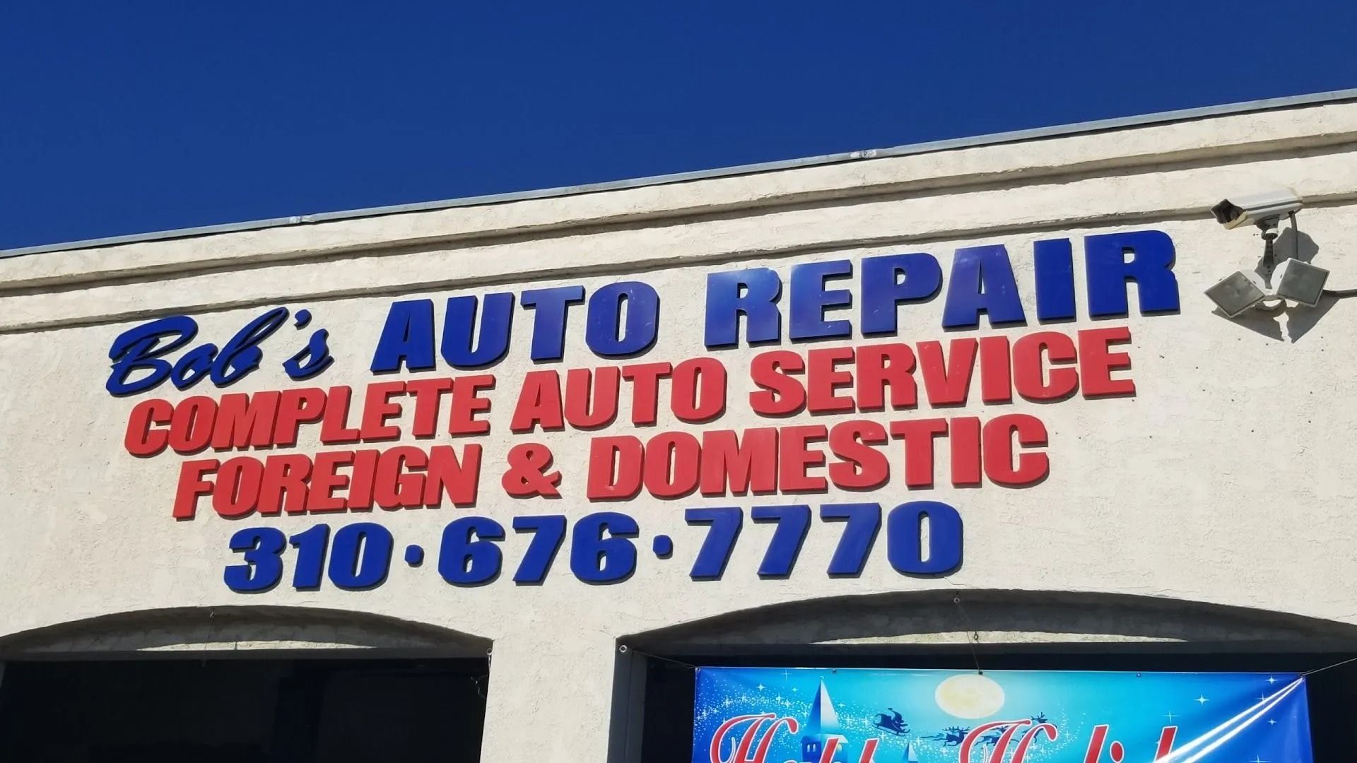 Bob’s Auto Repair storefront sign with blue and red lettering and phone number 310-676-7770 | Bob's Auto Repair