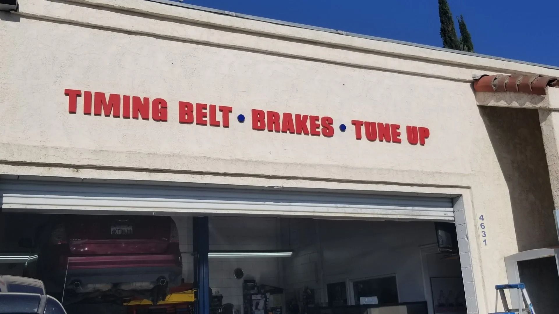 Auto repair shop sign reading “TIMING BELT • BRAKES • TUNE UP” above an open garage bay | Bob's Auto Repair