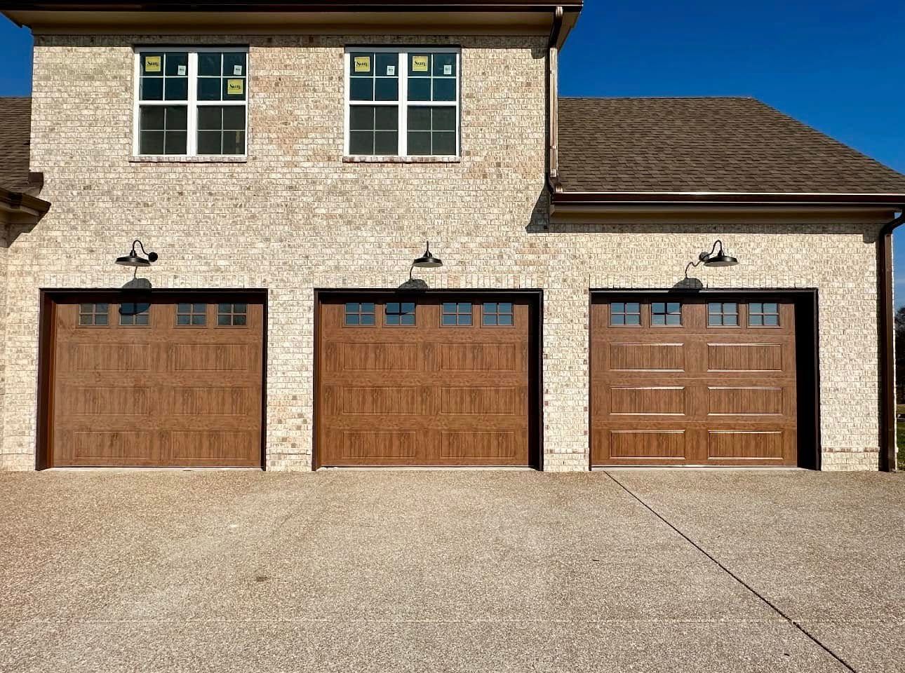 Three-car garage with brick exterior and wood doors, viewed from a driveway Three-car garage with brick exterior and wood doors, viewed from a driveway