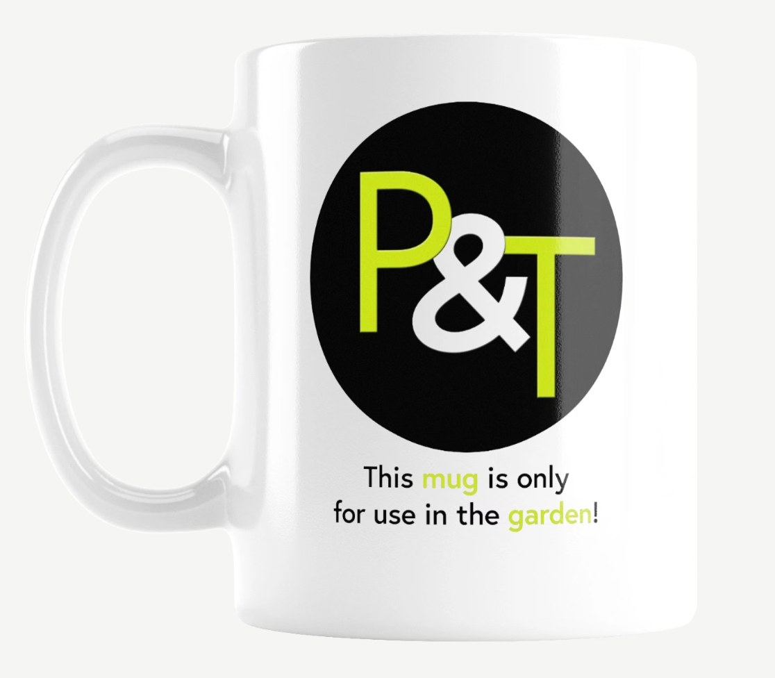 a white ceramic mug on a white background with the Pots and Trowels logo P and T in green and white on a black circle