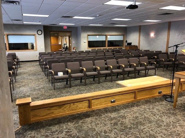 Empty conference room with rows of brown chairs and a wooden podium in front