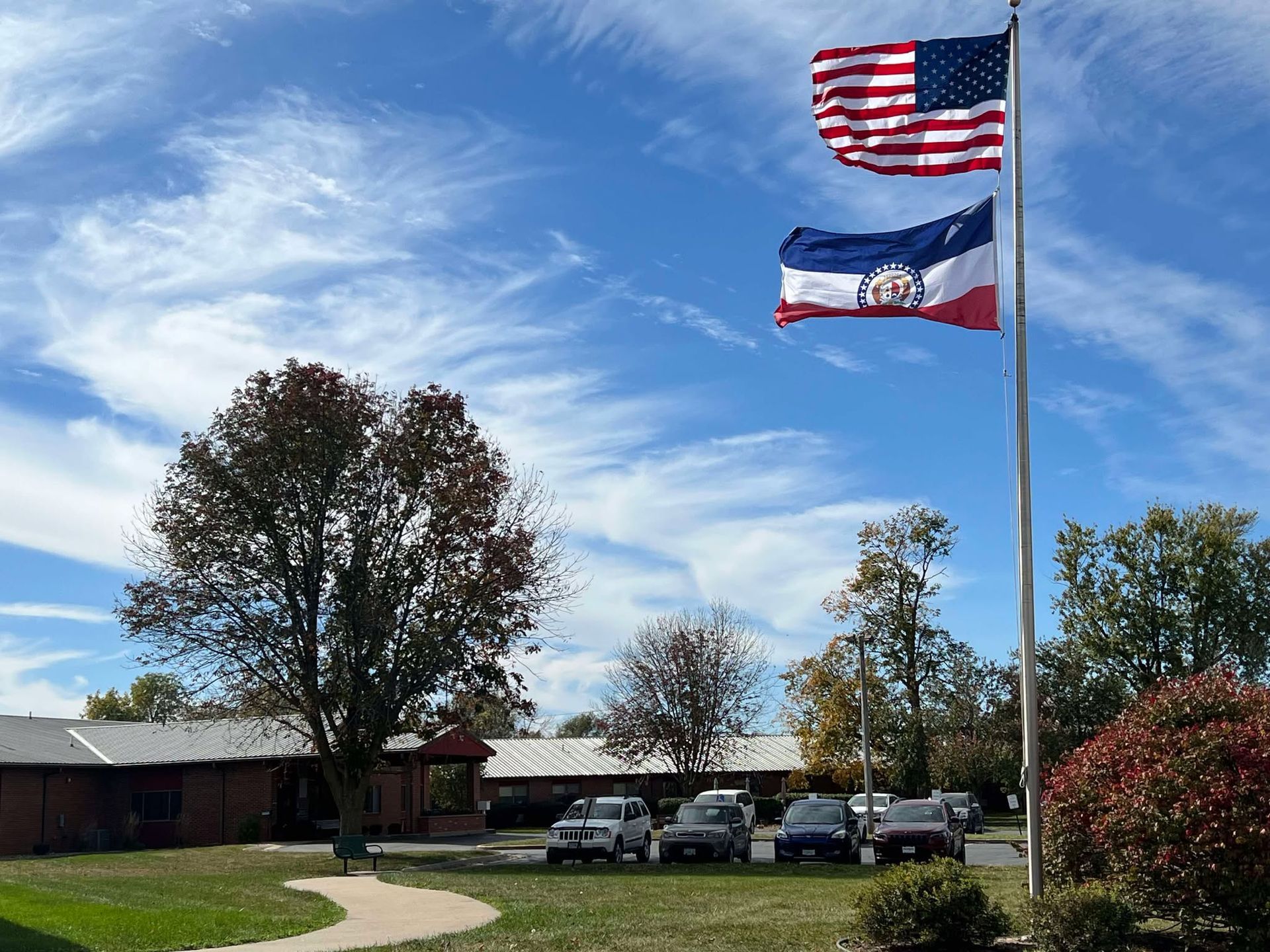 Two flags are flying in front of a building