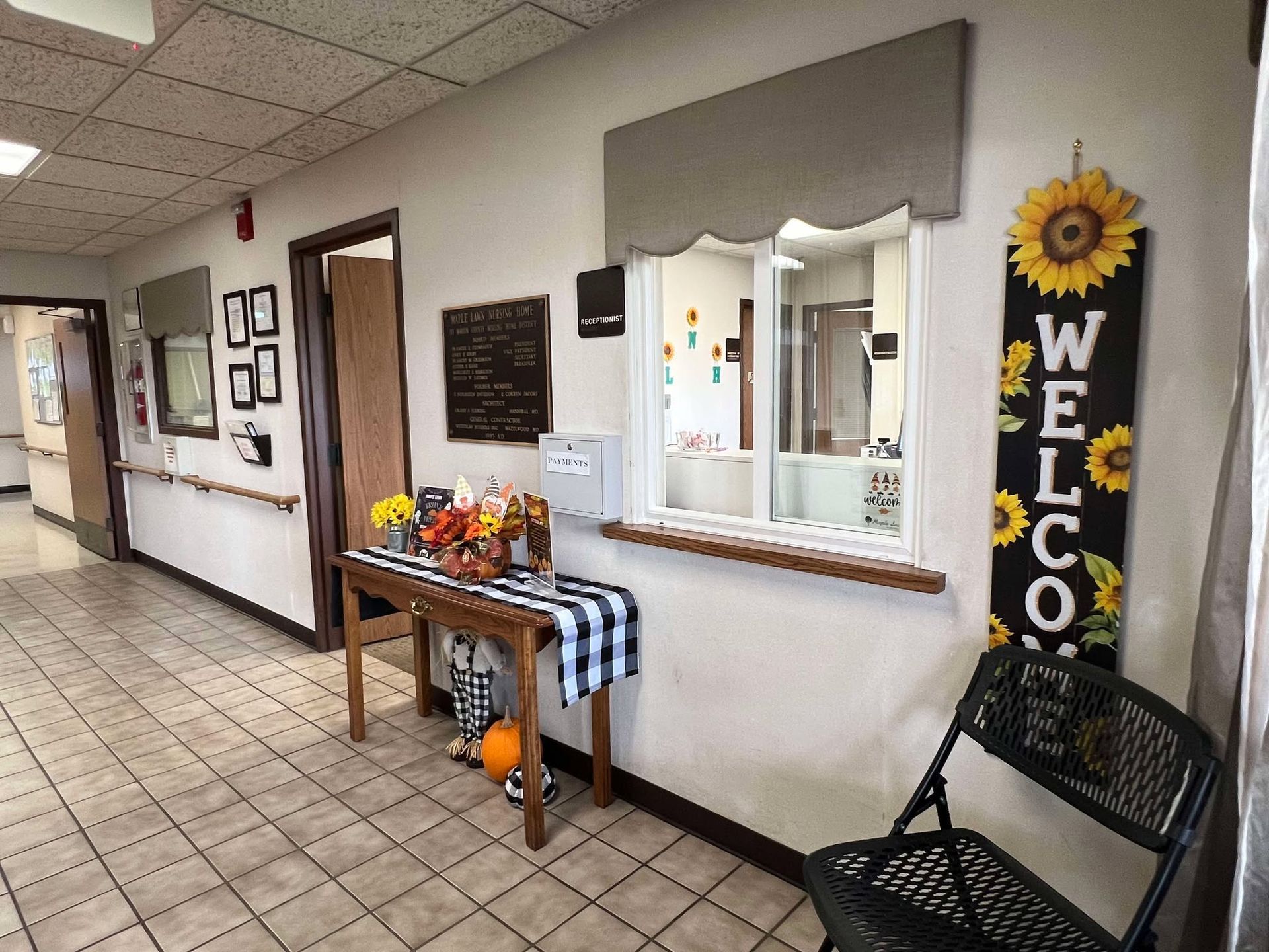 A hallway in a nursing home with a welcome sign hanging on the wall.