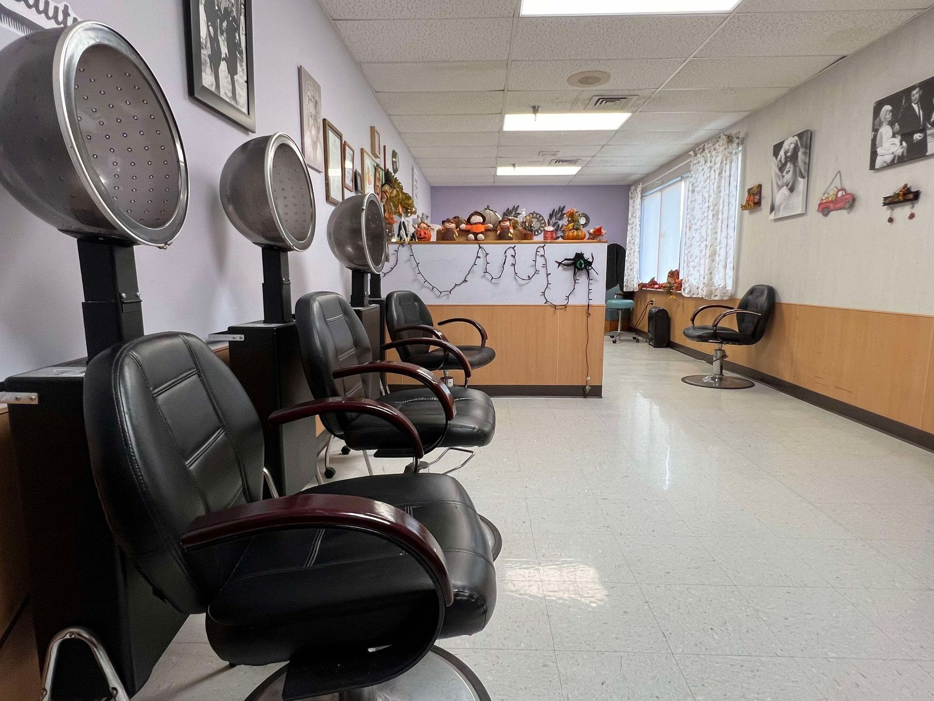A row of hair salon chairs are lined up in a room.