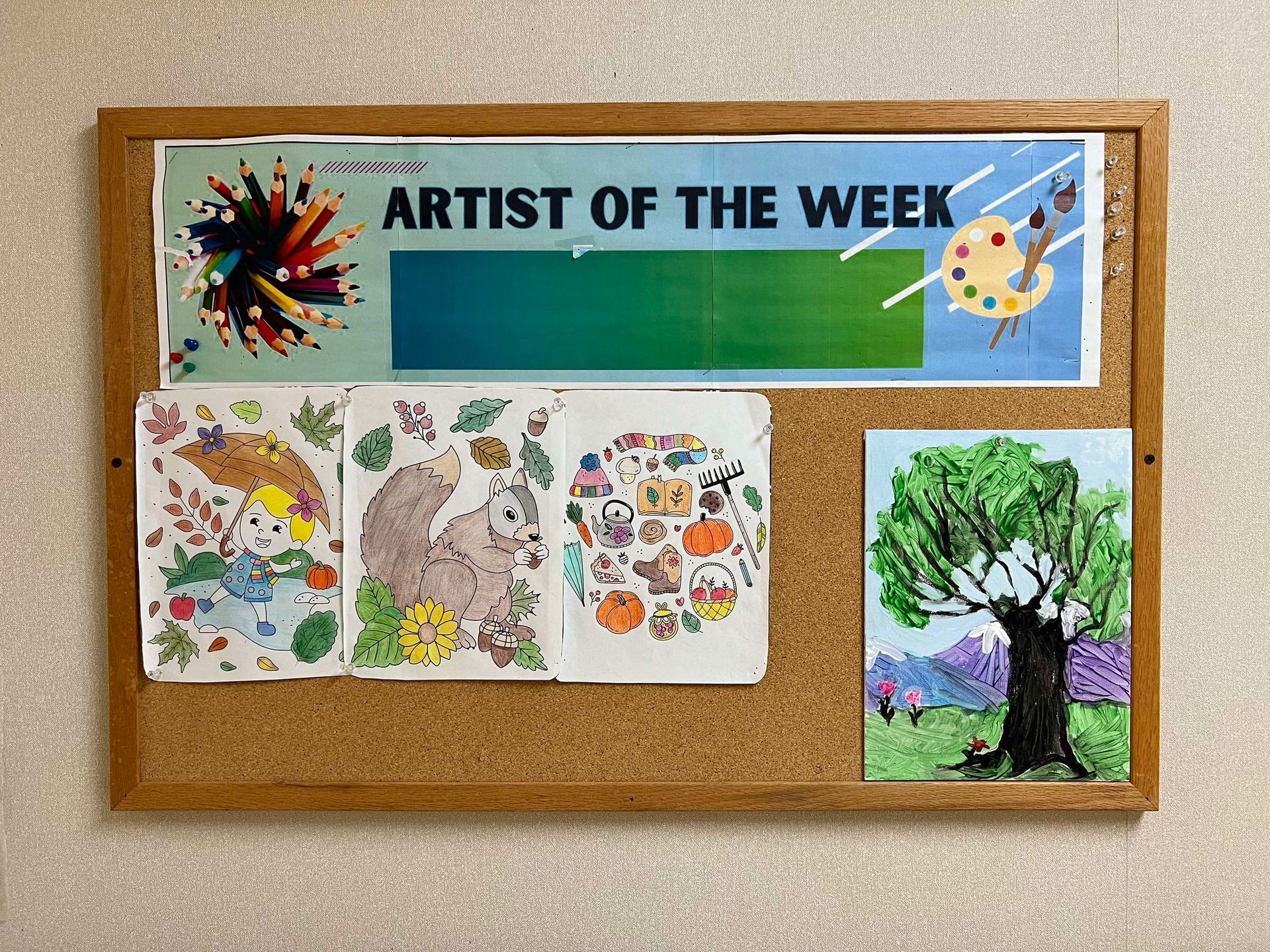 A cork board with a sign that says artist of the week