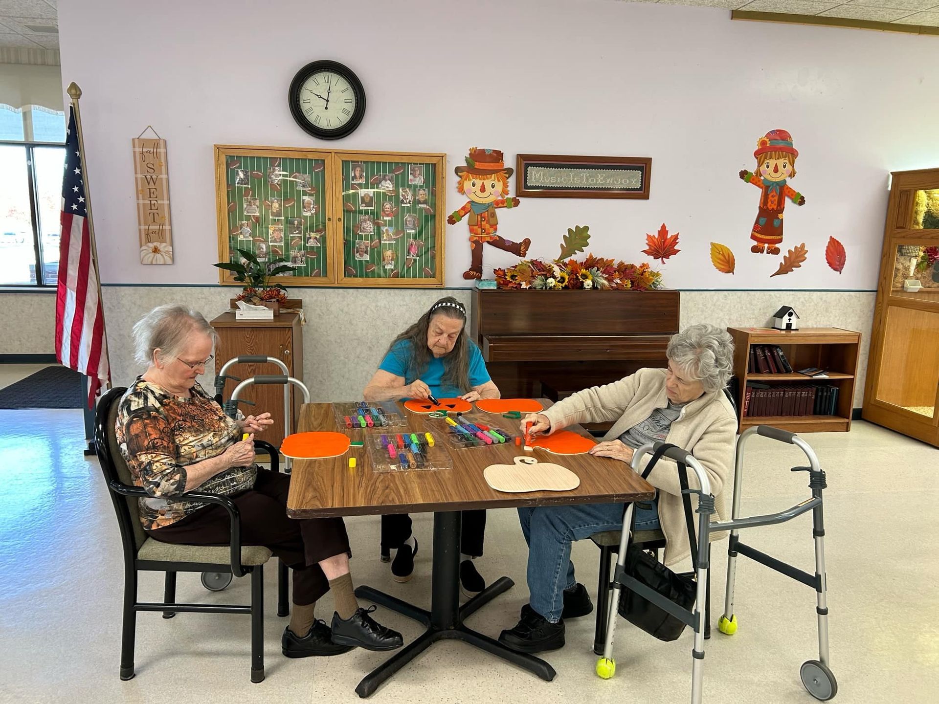 A group of elderly people are sitting around a table in a room.