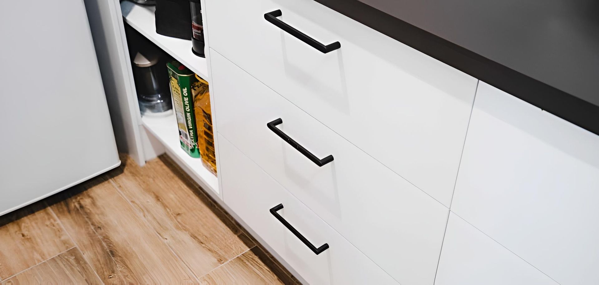 A Close Up of a Kitchen With White Cabinets and Black Handles — CK Cabinetry in Coolum Beach, QLD