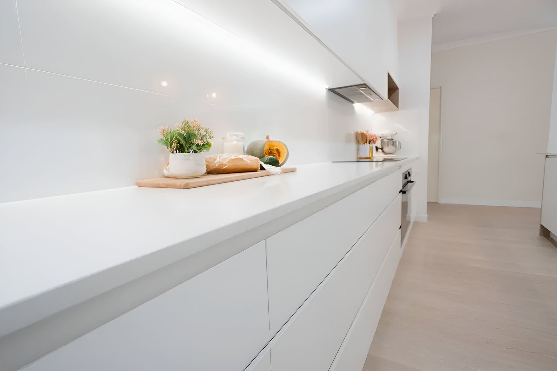 A Kitchen With White Cabinets and a Cutting Board on the Counter — CK Cabinetry in Coolum Beach, QLD