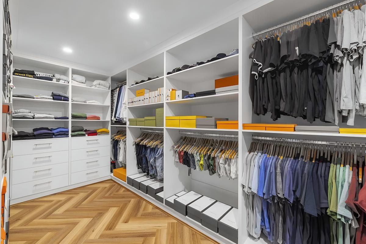 A Large Walk in Closet Filled With Lots of Clothes — CK Cabinetry in Noosa, QLD