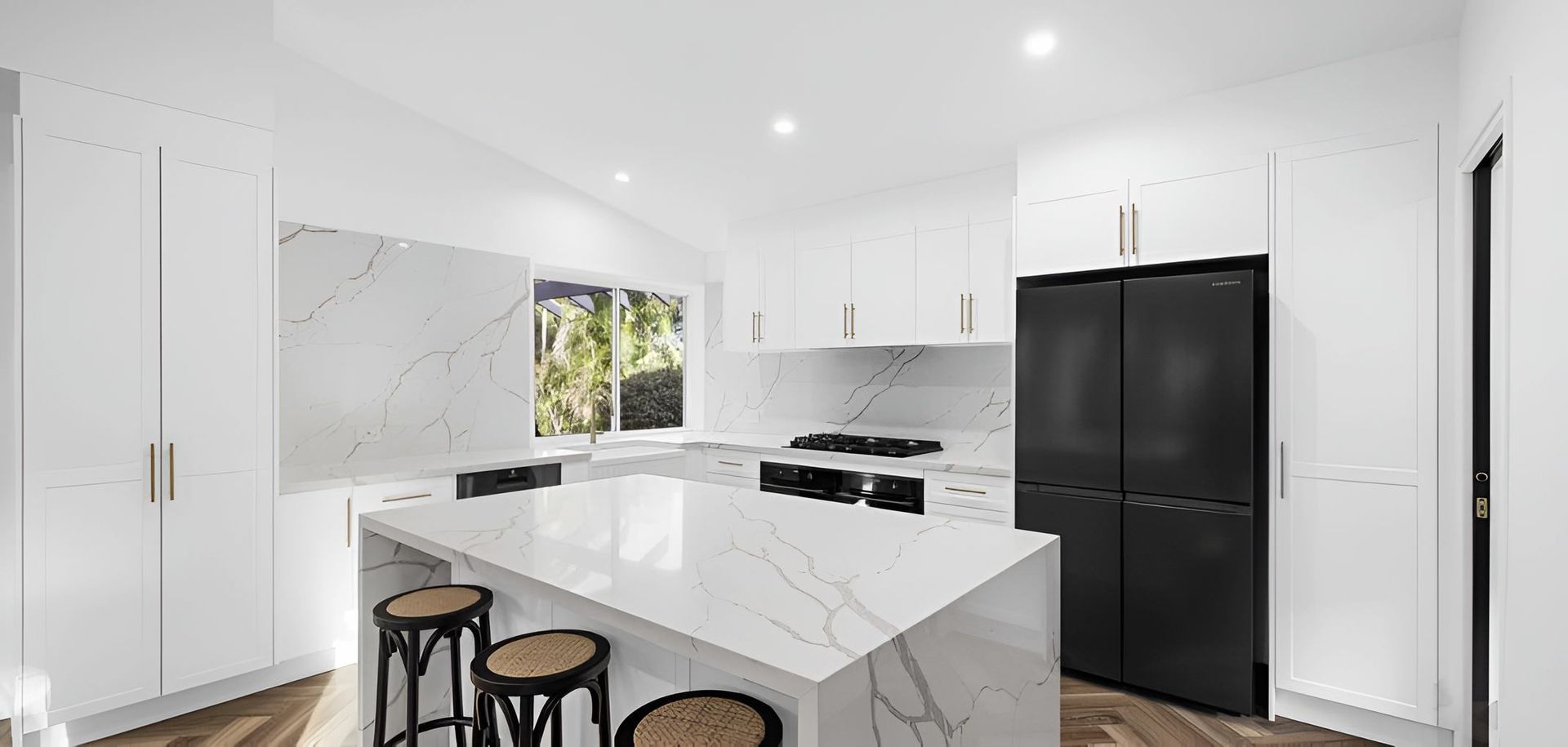 A Kitchen With White Cabinets and Black Appliances — CK Cabinetry in Coolum Beach, QLD