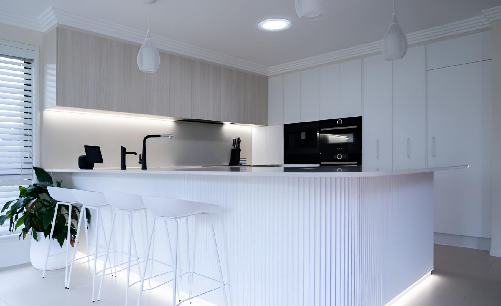 A White Kitchen With a Large Island and Stools — CK Cabinetry in Coolum Beach, QLD